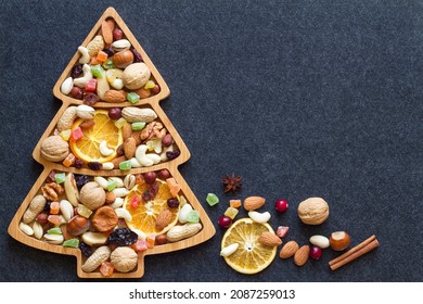 Christmas Mix Of Dried Fruit And Nuts In Christmas Tree-shaped Bowl On Dark Background