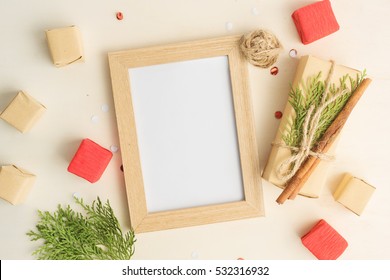 Christmas Mock Up With Photo Frame, Eco Gift Boxes In Paper And Tree Branches. New Year Celebration, Holiday Concept. Text Space.