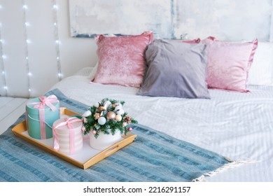 Christmas In Morning Living Room. Sofa Bed In Christmas Interior. Celebrate New Year And Holidays. Gifts On The Bed With A Christmas Bouquet, Pink Pillows At The Head