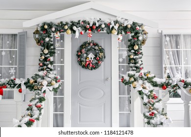 Christmas morning. porch a small house with a decorated door with a Christmas wreath. Winter fairy tale.