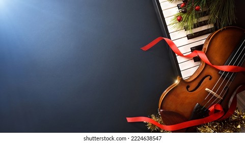 Christmas musical event concept background with piano and violin on black table and blue light. Top view. - Shutterstock ID 2224638547