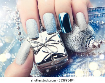 Christmas Nail art manicure idea. Winter Holiday style bright Manicure Design. Christmas decorations, snowflakes. Nail Polish. Beauty hands. Trendy Stylish Silver and Blue Colorful Nails, Nailpolish.