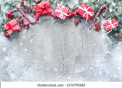 Christmas and New Year background with fir branches, gift boxes, ornament and snowfall on wooden white board - Powered by Shutterstock