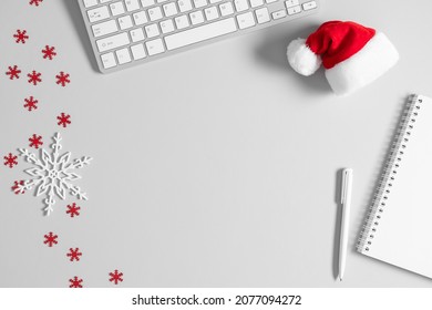 Christmas Or New Year Background. Office Table, Santa Hat, Christmas Decorations, Keyboard On Gray Table. Flat Lay, Top View, Copy Space