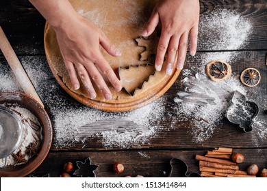 Christmas and New Year celebration traditions. Family home bakery, cooking traditional festive sweets. Woman cutting cookies of raw gingerbread dough