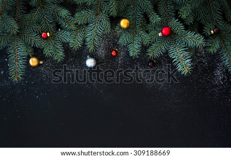 Christmas or New Year decoration background: fur-tree branches, colorful glass balls  on black grunge background with copy space