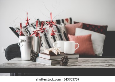 Christmas Or New Year Decoration On Modern Wooden Coffee Table. Cozy Sofa With Pillows On A Background. Living Room Interior And Holiday Home Decor Concept. Toned Picture