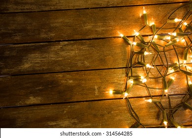 Christmas / New Year Fairy Lights On A Wooden Table To Be Used As Background Or Texture.