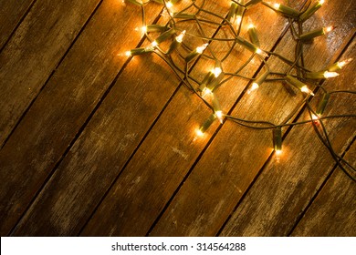 Christmas / New Year Fairy Lights On A Wooden Table To Be Used As Background Or Texture.