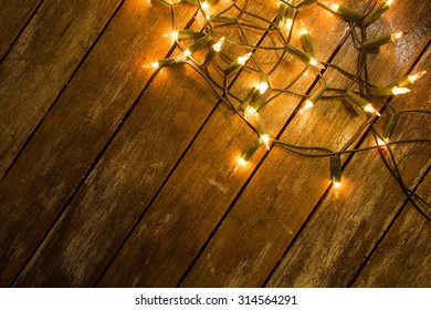 Christmas / New Year Fairy Lights On A Wooden Table To Be Used As Background Or Texture.