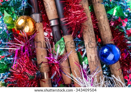 christmas and new year frame for postcard for fishers and anglers. fishing rods on bright spangles and ball background