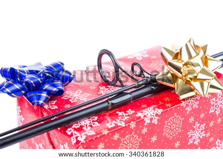 christmas and new year a gift and present in red box for fishers and anglers. fishing rod on present box from red paper with painting snowflakes