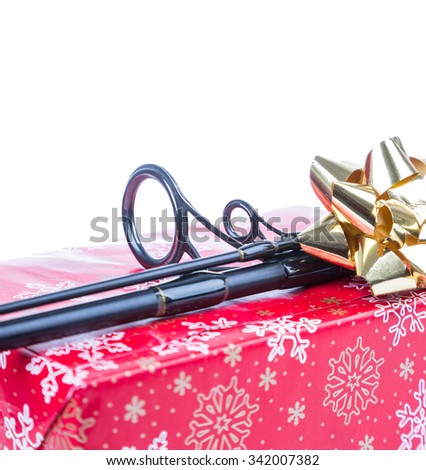 christmas and new year a gift and present in red box for fishers and anglers. fishing rod on present box from red paper with painting snowflakes