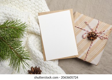 Christmas Or New Year Greeting Card Mockup With Envelope, Gift Box And Pine Tree Branch With Cones