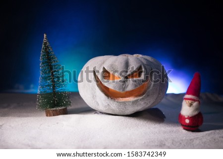 Christmas New Year or Halloween Celebrate Background with Little Christmas Tree and horror pumpkin on snow