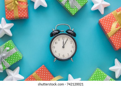 Christmas And New Year Holiday Composition With Gift Boxes, Stars, Clock On The Blue Background. Top View, Flat Lay. Copyspace