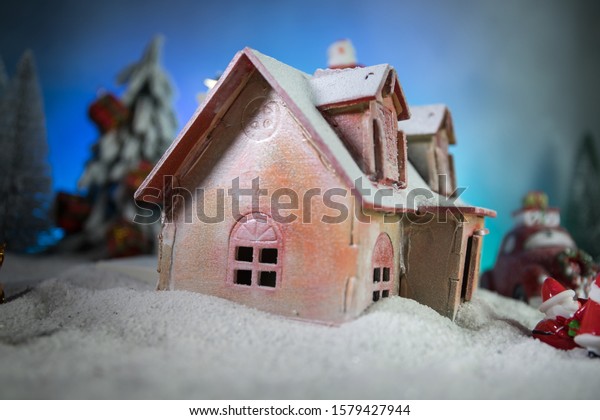 Christmas\
and New Year holidays concept. Little decorative cute small houses\
in snow at night. Traditional holiday attributes on snow. Creative\
artwork decorations. Empty space for your\
text