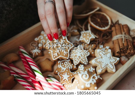 Christmas and New Year holidays, family weekend activities, celebration mood. Woman eating festive gingerbread sweets. Winter warming concept and cozy atmosphere