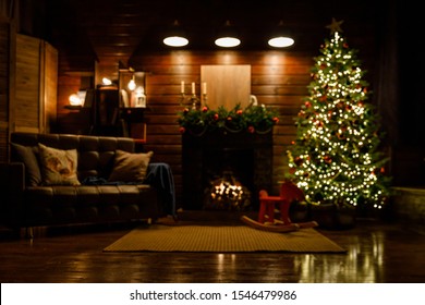 Christmas and New Year interior - blur background: fireplace, lamps, green Christmas tree, brown leather sofa, gifts, candles, moose rocking chair.  Lots of lights glowing in the dark. - Powered by Shutterstock