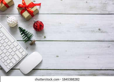 Christmas And New Year Office Work Space With Keyboard Pc, Wireless Mouse, Baubles, Gift Box And Christmas Tree On White Wood Desk, Flatlay Top View With Copy Space.