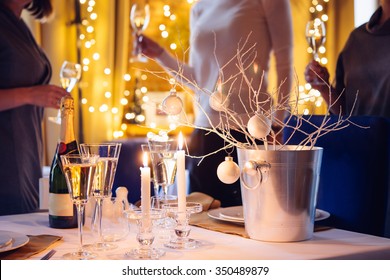 Christmas Or New Year Party Table With Champagne. Three Persons Stand Behind