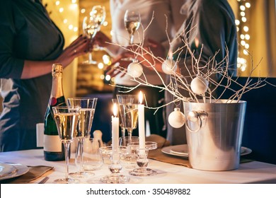 Christmas Or New Year Party Table With Champagne. Three Persons Stand Behind