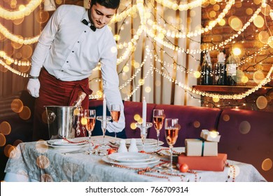 Christmas Or New Year Party Table In A Restaurant Or Cafe. Waiter Is Serving Table