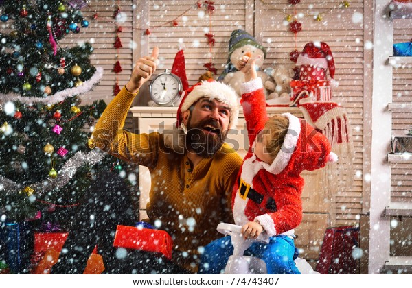 christmas new year snow concept Santa kid, bearded\
man at Christmas tree. Xmas party celebration. Christmas happy\
child and father with present box. Winter holiday and boxing day.\
New year man