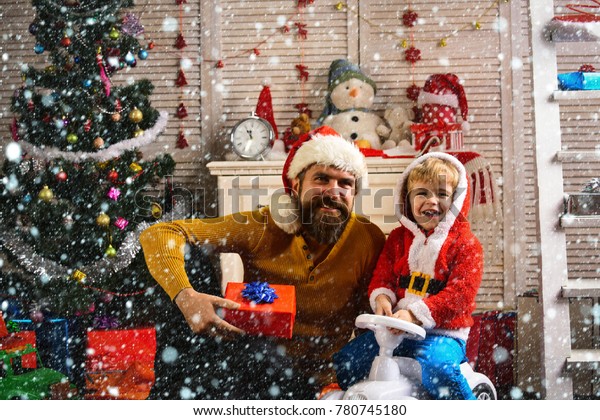 christmas and new year snow concept New year man and\
small boy on car. Winter holiday and boxing day. Christmas happy\
child and father with present box. Xmas party celebration, fathers\
day. Santa kid,