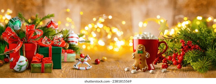 Christmas or New Year still life with gift boxes, Christmas treat, fir tree, winter berries and festive decor on a wooden table. Banner - Powered by Shutterstock