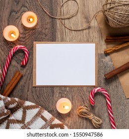 Christmas and New Year template for greeting card with candy canes, cinnamon sticks and candles. Square mockup with horizontal blank sheet of paper