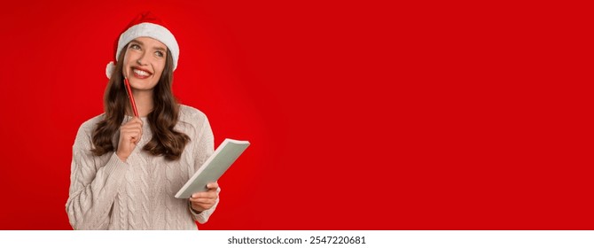 Christmas, New Year Wishes And Plans. Happy Lady In Santa Hat Posing With Pen And Notebook, Planning Upcoming Year, Writing Wishlist Letter To Santa Claus Over Red Background. Panorama, Copy Space - Powered by Shutterstock