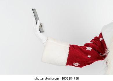 Christmas And New Years Concept. Santa Claus Holds A Mobile Phone In His Hand. No Face Visible. Isolated Background