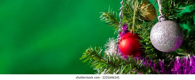 Christmas and New years eve green Background. Beautiful Wide Angle Holiday Template with christmas toys, red and gold ball on fir tree and highlights. Panoramic Web banner with copy space for design. 