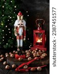 Christmas Nutcracker toy soldier on Christmas background with fir tree branches, nuts, lights. Elegant classic christmas background card for holidays