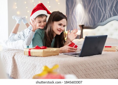 Christmas Online Family Congratulations. Smiling Mother And Son Using Mobile Tablet For Video Call Friends, Making X-mas Eve Skype Video Meeting Conference Waving Arms Congratulating Relatives.