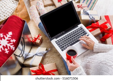 Christmas online shopping above view. Female buyer makes order on laptop, copy space on screen. Woman buy presents, prepare to xmas, among gift boxes and packages. Winter holidays sales - Powered by Shutterstock