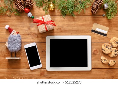Christmas online shopping background. Mobile and Tablet screen with copy space top view on wood, credit card and present boxes. Electronic devices, internet commerce on winter holidays concept