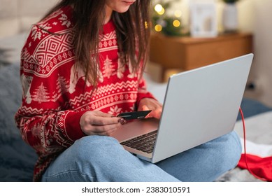 Christmas online shopping, sales and discounts promotions during winter holidays, online shopping at home. Female hands on the laptop with credit card and blurred bokeh lights - Powered by Shutterstock