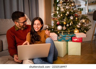 Christmas Online Shopping. Young couple with laptop buying online. Christmas and New Year Gifts. e-shopping - Powered by Shutterstock