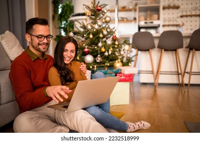 Christmas Online Shopping. Young couple with laptop buying online. Christmas and New Year Gifts. e-shopping - Powered by Shutterstock