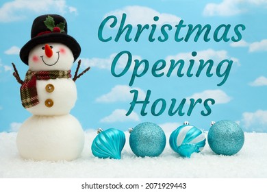 Christmas Opening Hours Message With Smiling Snowman With Hat, Ornaments, And Snow With Sky 