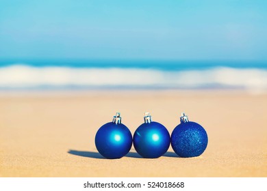 Christmas Ornaments In The Sand On A Tropical Beach