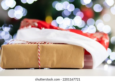 Christmas Parcel,christmas Gift In Santa Hat Under Christmas Tree