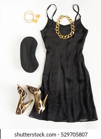 Christmas Party Outfit. Cocktail Dress Outfit, Night Out Look On White Background. Little Black Dress, Black Clutch, Leopard Shoes, Gold Necklace, Bracelets And Earrings. Flat Lay, Top View