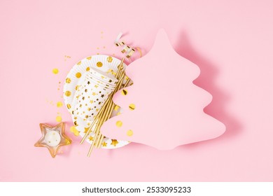 Christmas pink and gold background. Paper Christmas tree mockup for text and greetings. Bright plates with stars, glasses, straws, decorations, candles, confetti on pastel pink background. Flat lay - Powered by Shutterstock