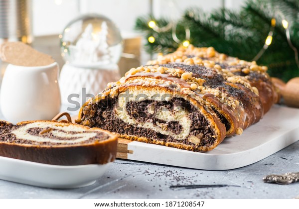 Christmas\
poppy seed cake, sliced poppy seed cake covered with icing and\
decorated with raisins and walnuts. Traditional Christmas cake in\
Poland. Christmas dish. Christmas eve.\
Xmas.