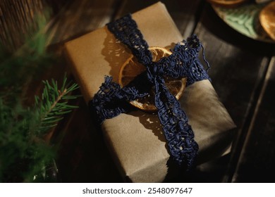 Christmas present decorated with lace ribbon and dried orange. Elegant Christmas gift box wrapped in eco friendly brown paper. - Powered by Shutterstock