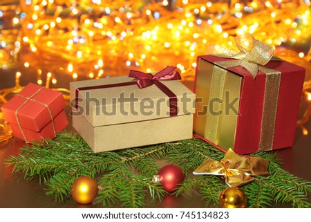 Christmas presents gift box, colored balls under a Christmas tree with defocused lights