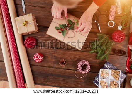 christmas presents wrapped in eco paper with homemade decoration on wooden background with decor elements and units